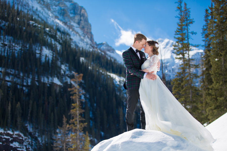bride and groom standing at the foot of a mountain