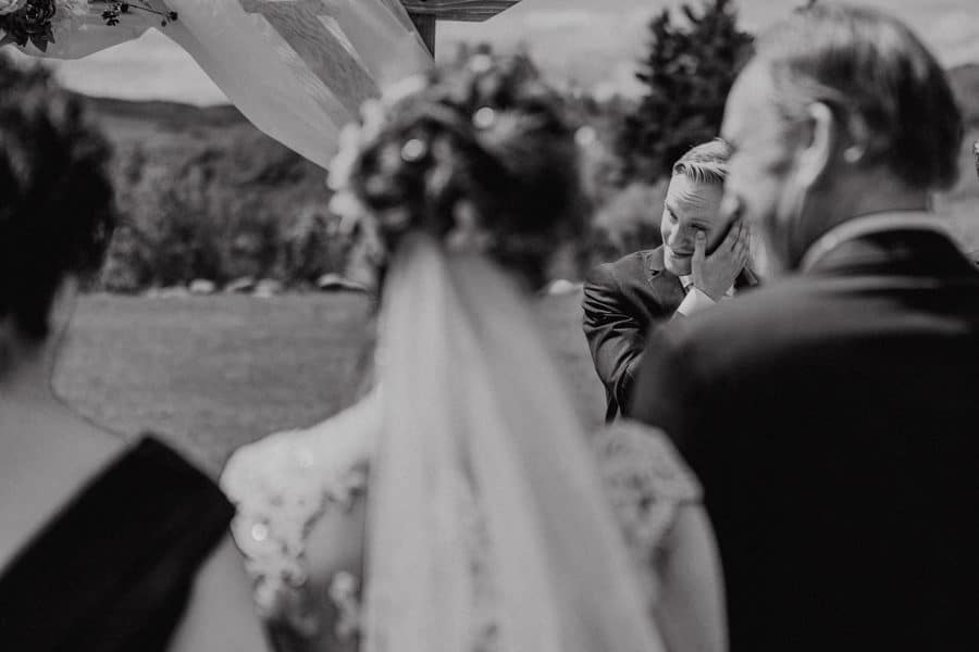 groom reacting to bride walking down the aisle of the cochrane race house