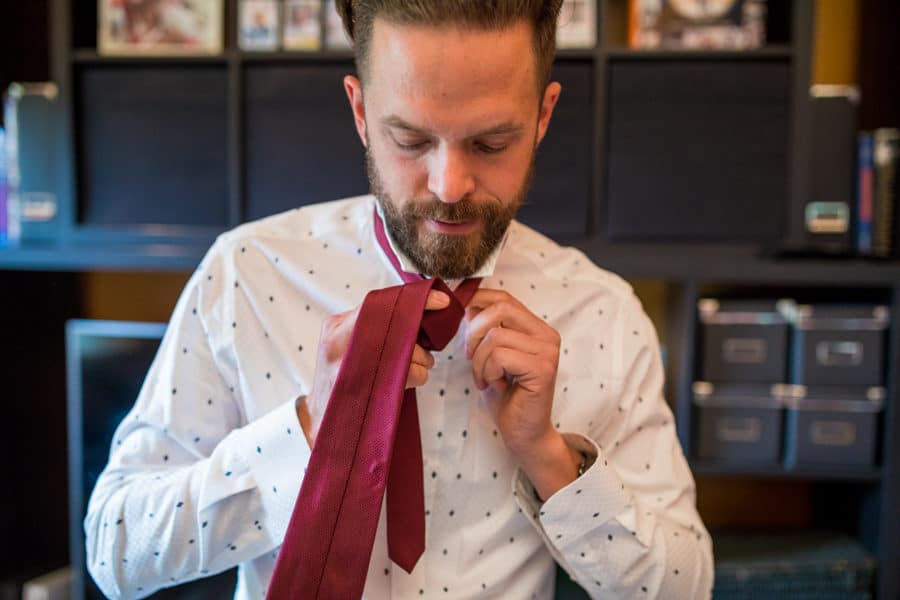 groom putting on his tie