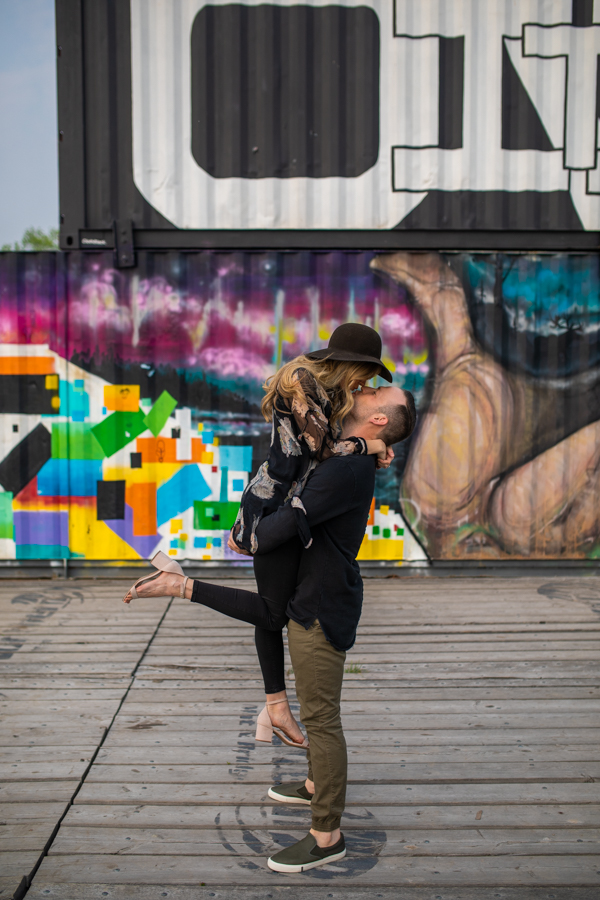 guy getting a big kiss during an engagement session in Calgary
