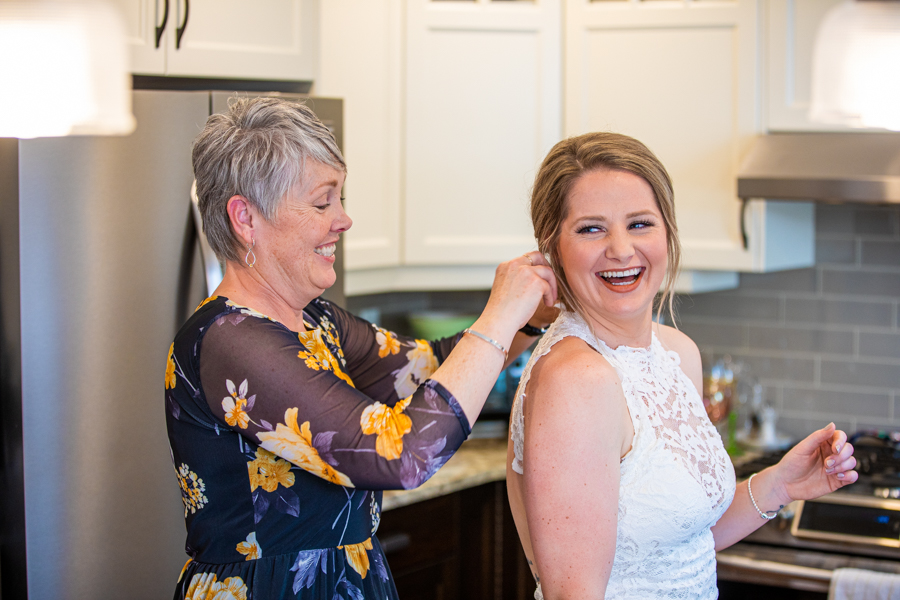 mom helping bride with her hair