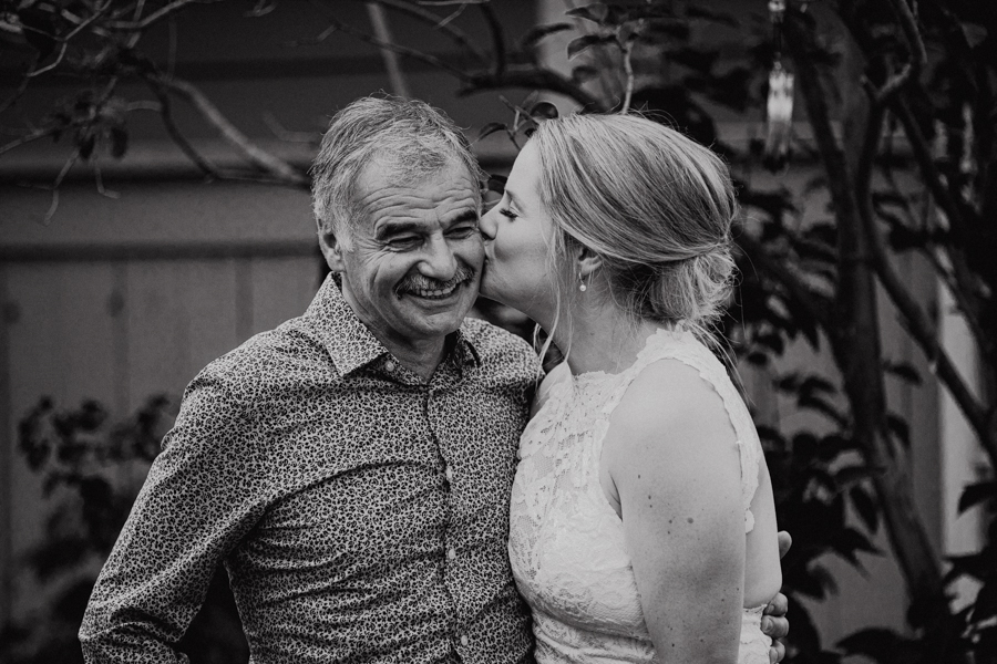 bride giving father a kiss on the cheek