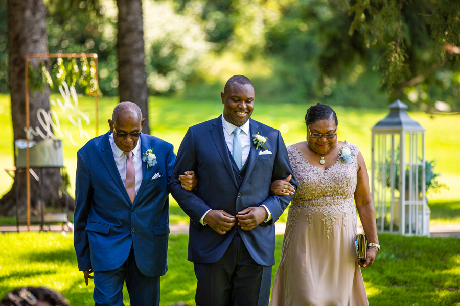 mother and father walking son down the aisle at riverside golf course