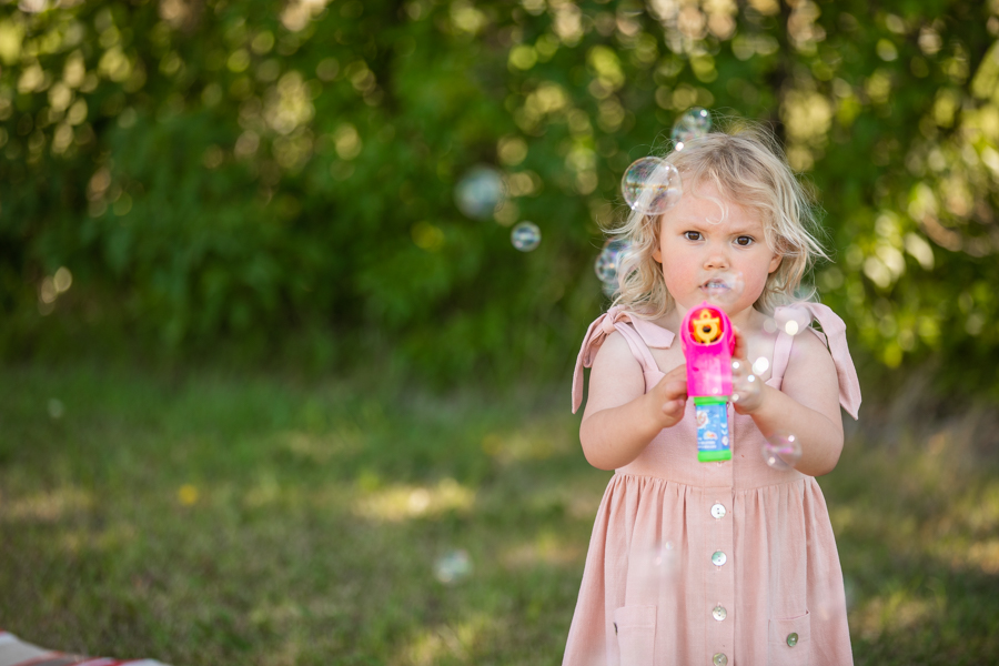 little girl playing with bubbles for family photos