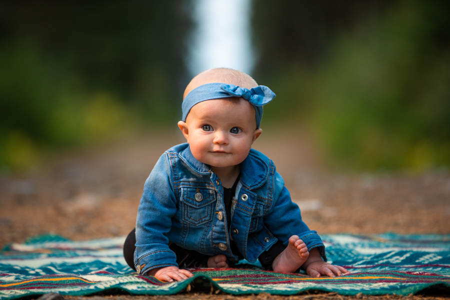baby girl sitting on a blanket for portrait